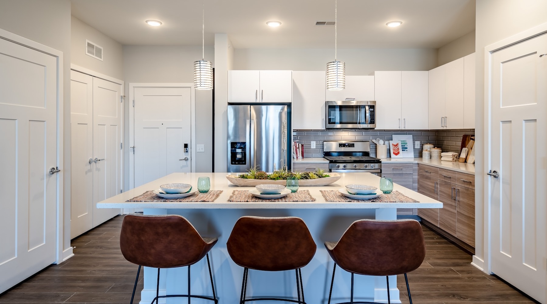 Refined spaces to match your style kitchen with large island and stainless steel appliances